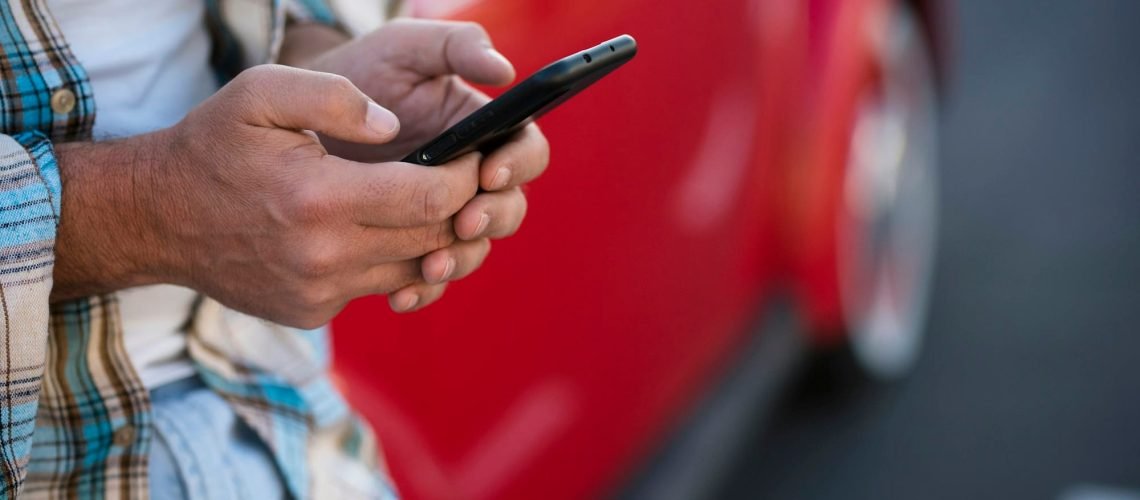 Close up of man using phone outdoor - unrecognizable people with cellular smartphone chatting