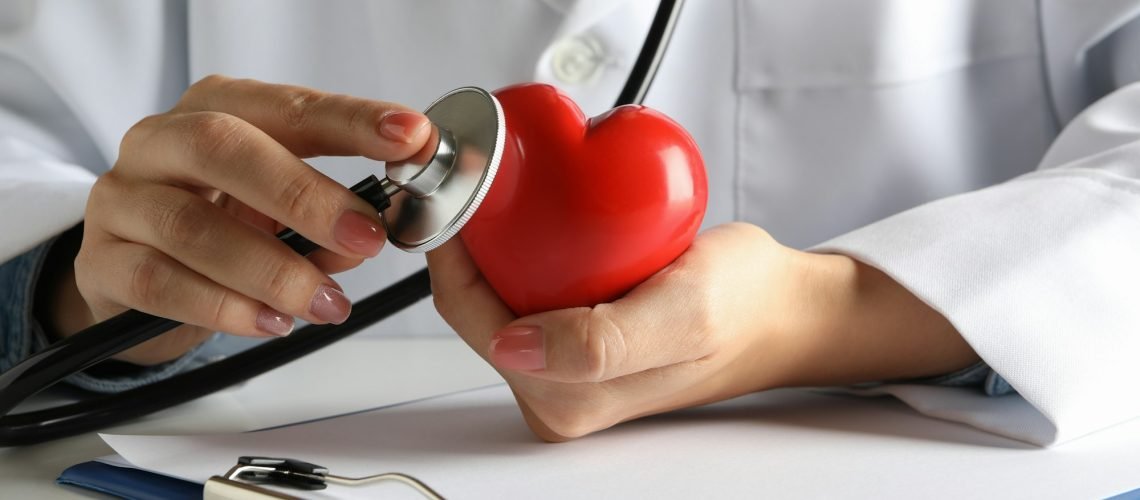 Female doctor with stethoscope checking heart beat